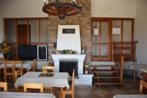 Penzión Vínny Dom في Streda nad Bodrogom: غرفة طعام بها موقد وطاولات وكراسي