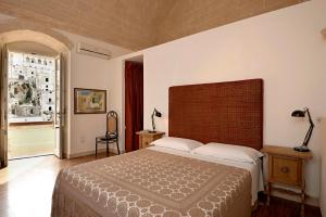 - une chambre avec un grand lit et une grande fenêtre dans l'établissement Fra I Sassi Residence, à Matera