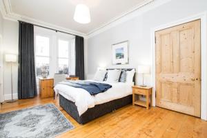 a bedroom with a large bed and a large window at Beautiful, Traditional 2 Bedroom Main Door Flat in Edinburgh