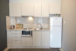 a kitchen with white cabinets and a white refrigerator at DreamHouse 1 - Komotini in Komotini