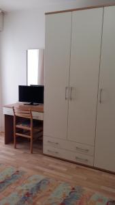 a room with a desk and a computer and white cabinets at Hotel Augusta in Caorle