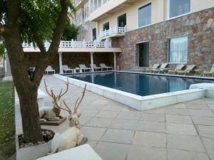 a swimming pool with a deer statue next to a building at Fateh Niwas by Fateh Collection in Udaipur