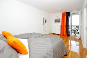 una camera da letto con un grande letto con cuscini arancioni di Apartment Bonium a Spalato (Split)