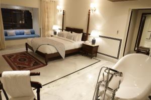 een slaapkamer met een bed, een bad en een wastafel bij Laxmi Palace in Dausa