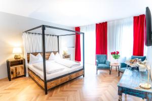 a bedroom with a four poster bed with red curtains at Altstadt Liebling in Vöcklabruck