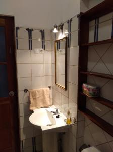 a bathroom with a sink and a mirror at Edificio Magico in Tarrafal