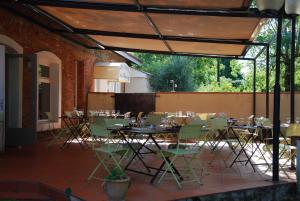 a group of tables and chairs in a patio at Hôtel Le Barry, Toulouse Nord in Gratentour