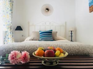 uma taça de fruta numa mesa em frente a uma cama em Casa Buleria em Jerez de la Frontera