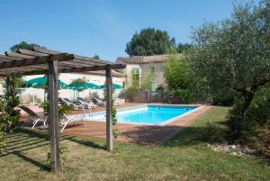 a swimming pool with a pergola next to a house at Hôtel Le Barry, Toulouse Nord in Gratentour