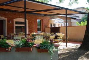 a patio with a restaurant with tables and chairs at Hôtel Le Barry, Toulouse Nord in Gratentour