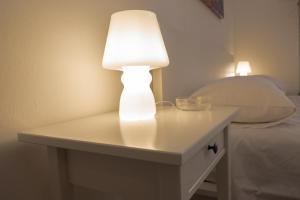 a white lamp on a table next to a bed at Centro A Casuzza in Palermo