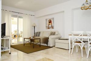 ein Wohnzimmer mit einem weißen Sofa und einem Tisch in der Unterkunft Nice apartment in Fuentes de Nerja in Nerja