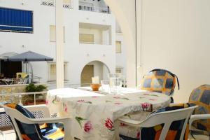 einem Tisch mit Stühlen und einer Tischdecke in der Unterkunft Nice apartment in Fuentes de Nerja in Nerja