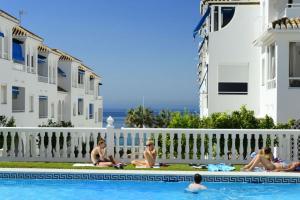 eine Gruppe von Personen, die im Pool eines Resorts sitzen in der Unterkunft Nice apartment in Fuentes de Nerja in Nerja