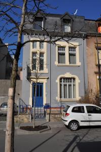 un coche blanco estacionado frente a una casa en Apart1hotel, en Luxemburgo