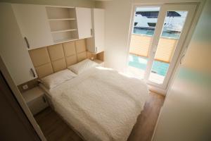 ein kleines Schlafzimmer mit einem Bett und einem Fenster in der Unterkunft Marina Luxury Houseboat Lace in Portorož