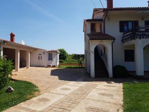 una casa bianca con un arco in un cortile di Apartment Ulika a Marčana