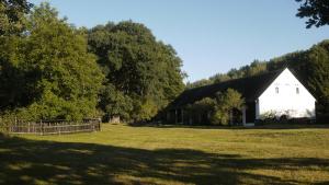 a large white barn in a field with trees at Silna Nowa 2 in Pszczew