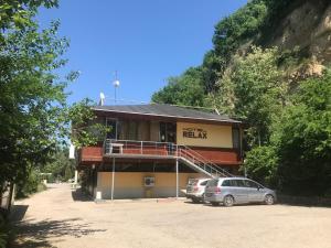a building with two cars parked in front of it at Family Hotel - Relax in Ruse