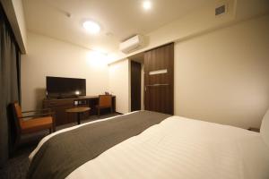 Postel nebo postele na pokoji v ubytování Dormy Inn Oita