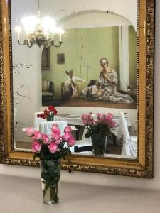 two vases with flowers in front of a mirror at Tulipán Villa Panzió in Szolnok