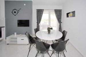 a dining room with a white table and chairs at Vito in Bibinje
