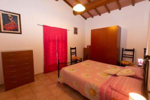a bedroom with a bed and a dresser and red curtains at Appartamenti Massarella in Fucecchio