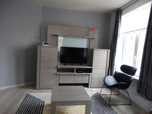 伊普爾的住宿－Aan de vestingrand，客厅配有平面电视和椅子。