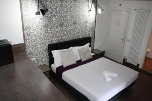 1 cama con sábanas blancas y almohadas en una habitación en Relais Palazzo Taverna, en Roma