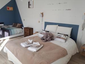 einem ausgestopften Teddybär auf einem Bett mit Handtüchern in der Unterkunft Maison d'hôtes "At'Home" in Ault