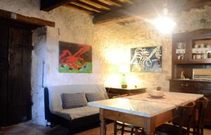 una sala de estar con una mesa y un sofá en Casa Portone Paola, en Campiglia dʼOrcia