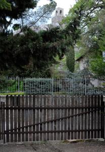 una cerca frente a una casa con una iglesia en Casa Portone Paola, en Campiglia dʼOrcia