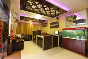 a large room with a fish tank and a bar at Royal Grand in Tambaram
