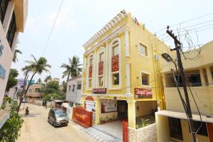 a yellow building on the side of a street at Royal Grand in Tambaram