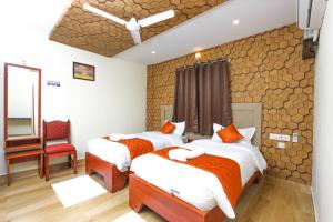 a hotel room with two beds and a chair at Royal Grand in Tambaram