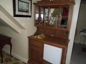 baño con lavabo y armario de madera en Kearsarge Inn en North Conway