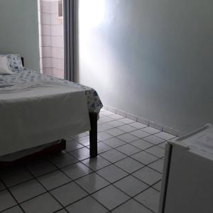 a bedroom with a bed and a white tiled floor at Pousada Ipojuca in Caruaru