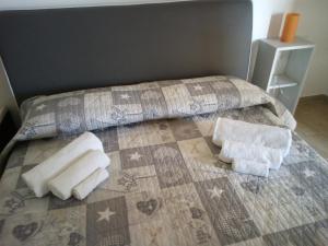 1 cama con 2 almohadas y toallas en Villa Maricla, en Marinella di Selinunte