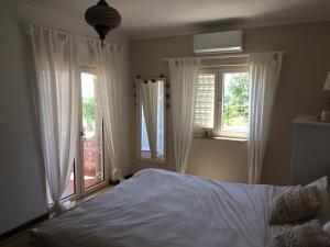 een slaapkamer met een bed en twee ramen bij Cegonha Villa powered by Cegonha Resort- Private swimming pool & air con in Albufeira +25 foto's