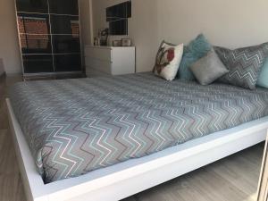 a large bed in a bedroom with a bed frame at Loft-Entre a praia e o campo in Nazaré