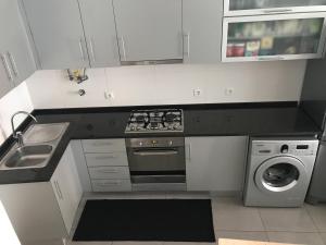 a kitchen with a stove top oven next to a dishwasher at Loft-Entre a praia e o campo in Nazaré