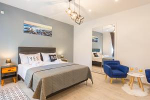um quarto com uma cama e uma cadeira azul em Rooms Sea & Sun with private parking em Zadar