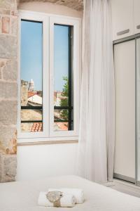 1 dormitorio con cama y ventana en Fairy Of The Seas Apartments, en Split