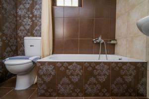 uma casa de banho com um WC e uma banheira em Marika Traditional Home em Élos