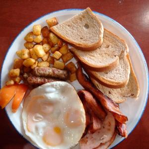 a plate of breakfast food with eggs bacon and toast at Kottamba Yala Stay & Safari in Tissamaharama
