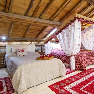 a bedroom with two beds and curtains in a attic at Loft Giuly in Vignanello