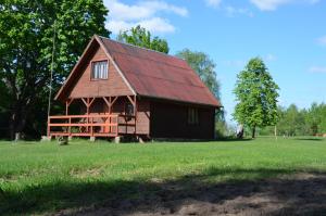 stodoła z czerwonym dachem na polu trawy w obiekcie Domek całoroczny MARKO w Węgorzewie