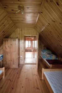 a wooden cabin with a bed and a hallway at Domek całoroczny MARKO in Węgorzewo