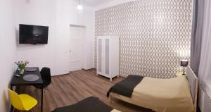 a bedroom with a bed and a desk and a tv at Apartamenty Równa in Kielce