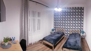 a bedroom with two beds and a table in it at Apartamenty Równa in Kielce